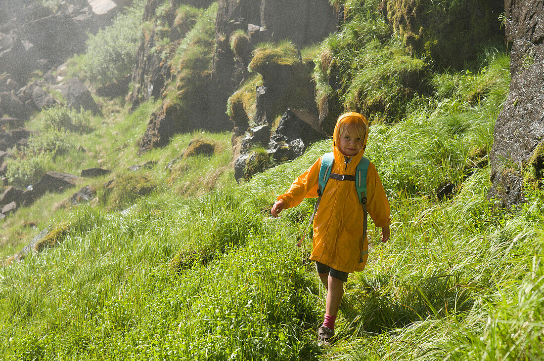 A young girl hiking a wet grassy slope, Rio Grande National Forest, Creede, Colorado., Creede, Colorado, usa