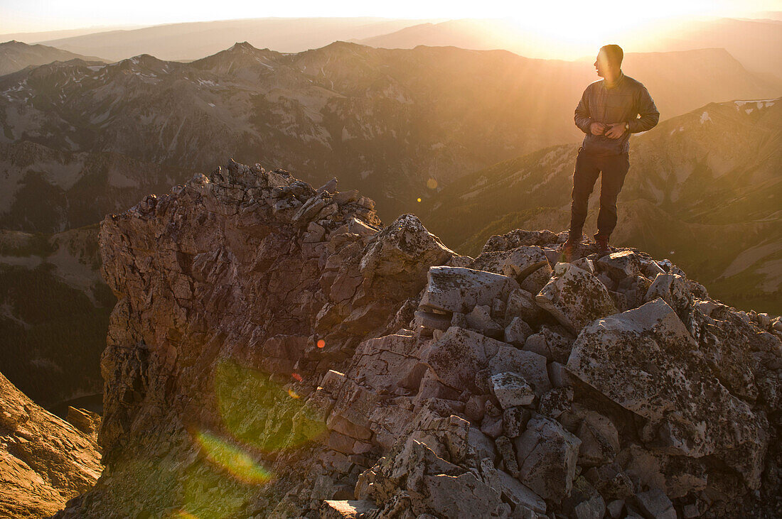 A man standing on the summit ridge of Capitol Peak at sunset, White River National Forest, Aspen, Colorado., Aspen, Colorado, usa