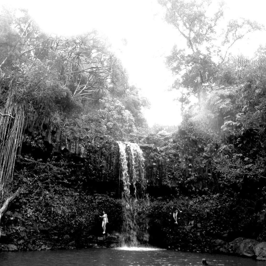 A black &amp;amp; white image of two girls swimming at a waterfall in Maui., Maui, Hawaii, USA