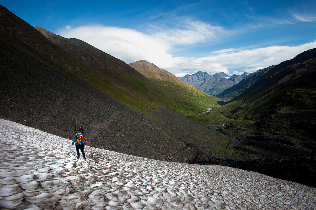 One woman hiking over a snowy pass in big mountains., Anchorage, AK, USA