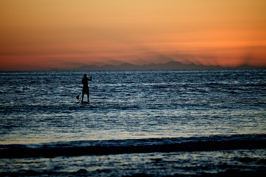 A male enjoying an evening stand up paddle board session with the last light of the day. Baja Mexico.(silhouette), Baja, Mexico