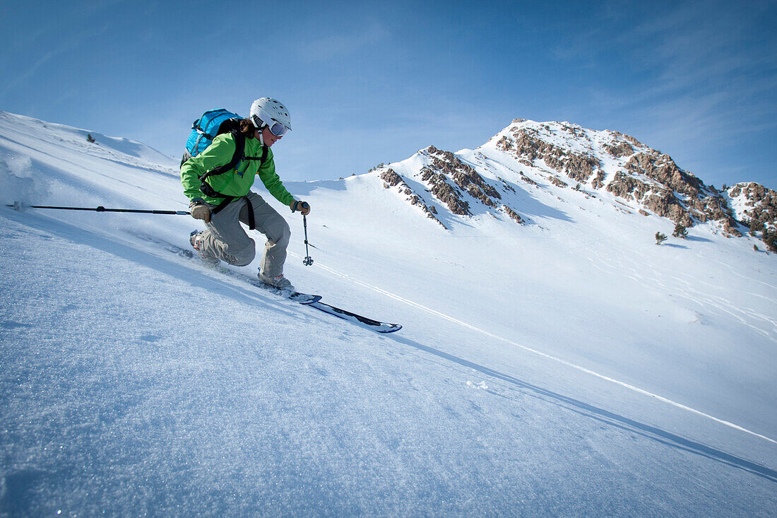 One female telemark skier making a hard turn., Ogden, Utah, USA