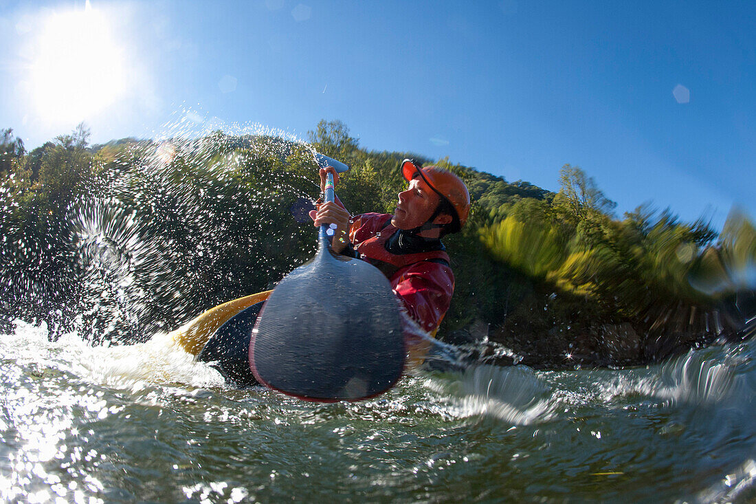 Low angle perspective of one man splashing in a kayak / playboating., Fayetteville, WV, USA