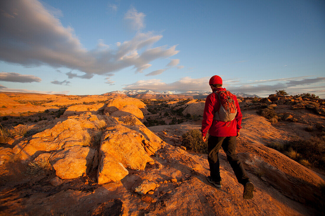 Young man hiking on slickrock near Moab, Utah., Moab, Utah, USA