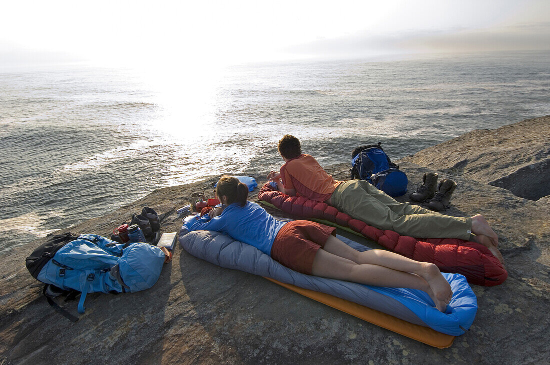 Couple camp on rocky ocean coast Sydney, New South Wales, Australia