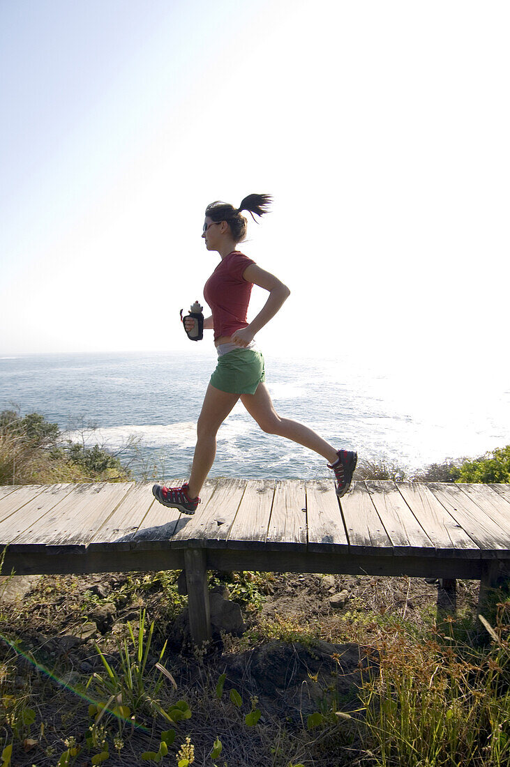 Runner on bridge along ocean trail Sydney, New South Wales, Australia