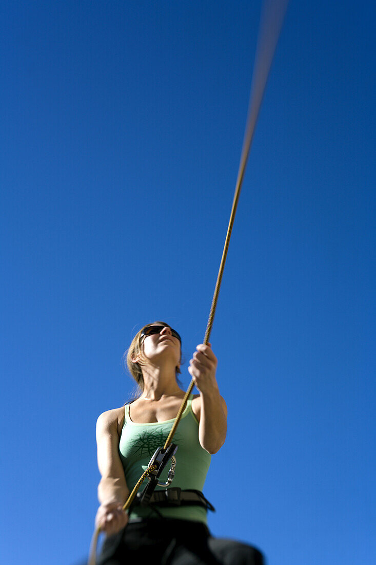 Low angle of a woman belaying, Bishop, California, United States