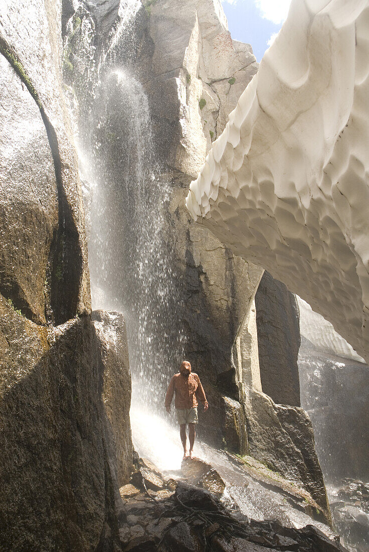 Hiker cooling off in waterfall Bridgeport, California, United States