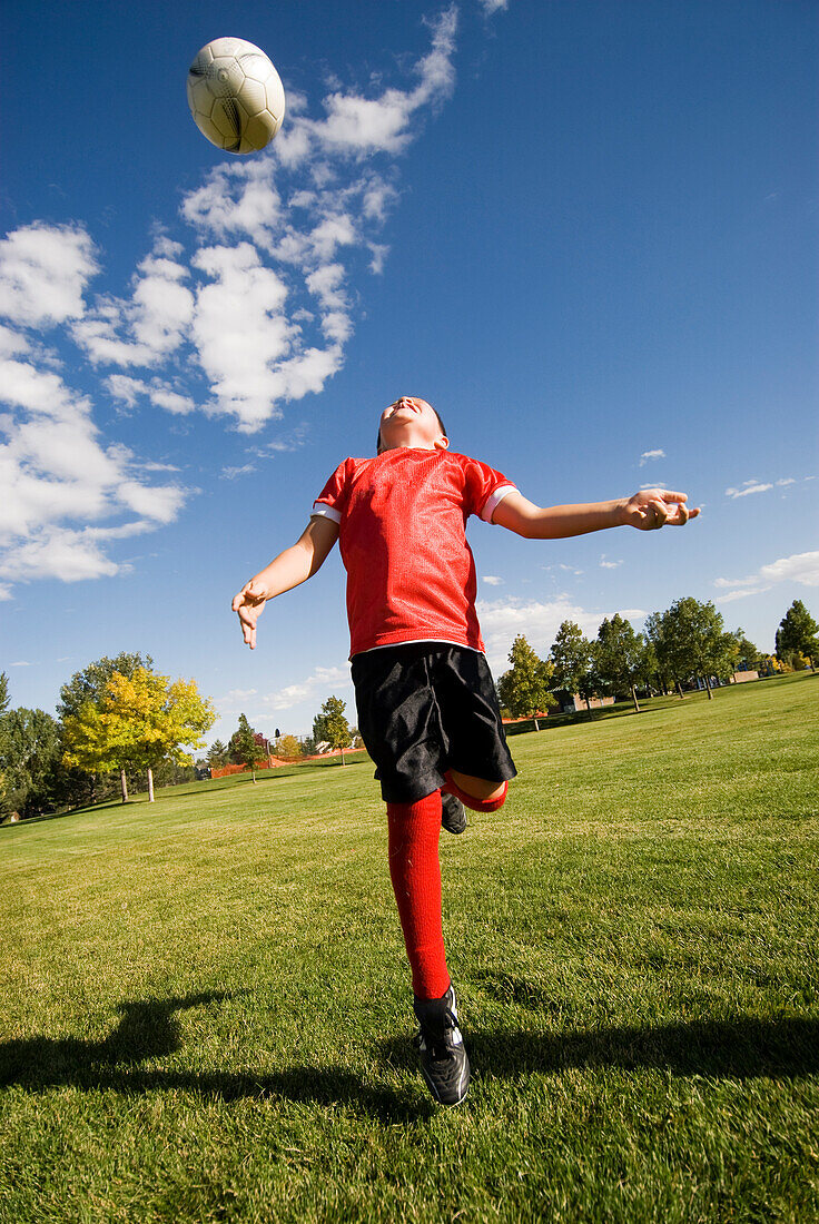 A boy does a header with the soccer ball in Fort Collins, Colorado Fort Collins, Colorado, USA