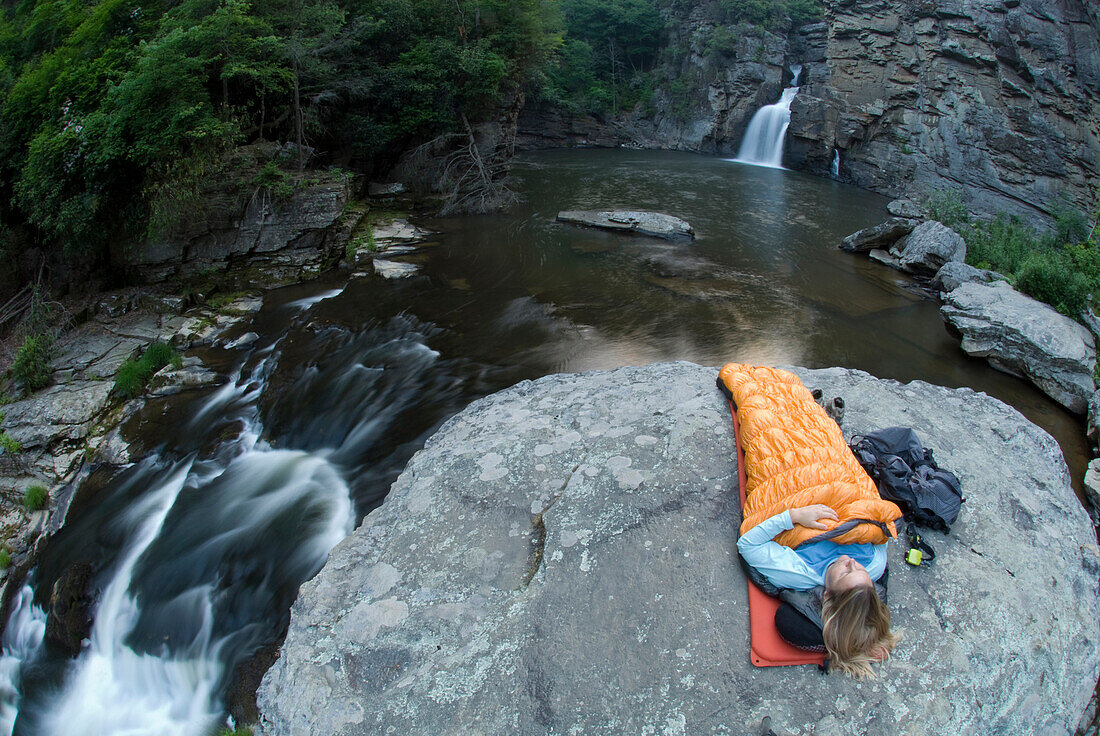 Woman camping on rock below Linville Falls, North  Carolina Spruce Pine, North Carolina, USA