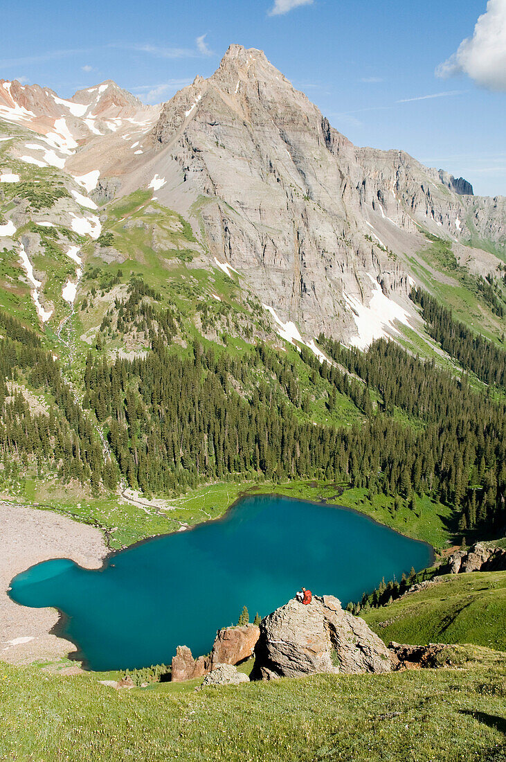 A woman on a rock above Blue Lake, Uncompaghre National Forest, Colorado Ridgeway, Colorado, USA