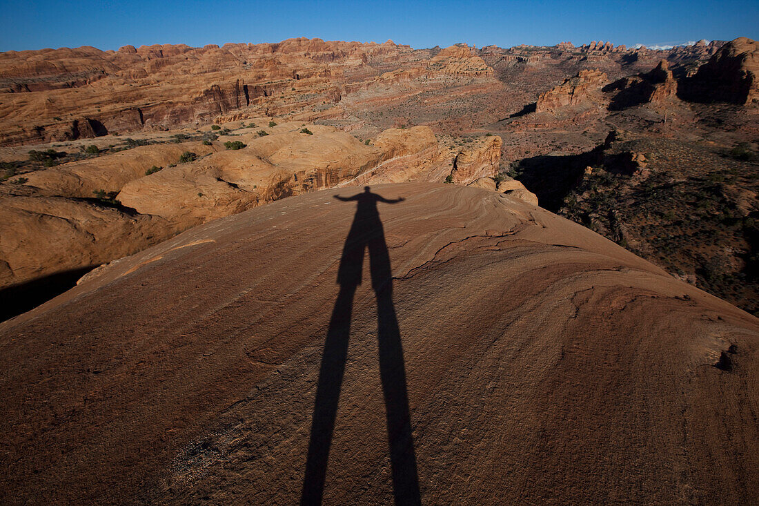 Shadow of a photographer on red rocks near Moab, Utah Moab, Utah, USA