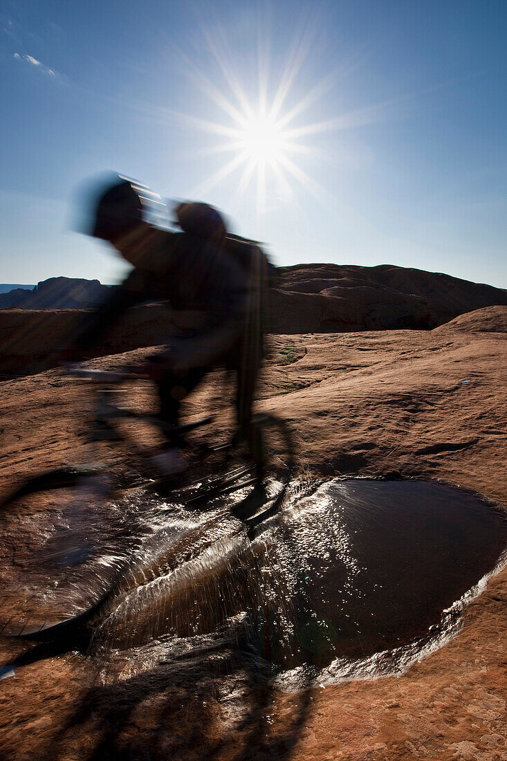 Mountain biker riding on the slickrock trail in Moab, Utah. (motion blur), Moab, Utah, USA