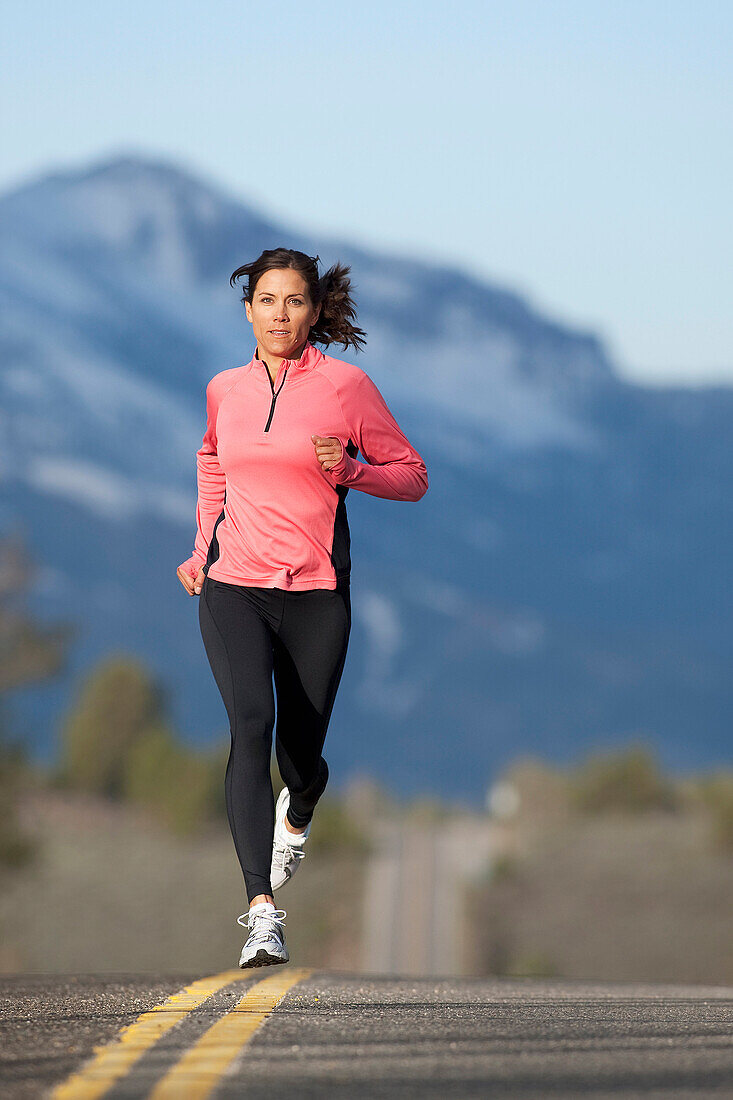 An athletic woman running on a mountain road in South Lake Tahoe, California South Lake Tahoe, California, USA