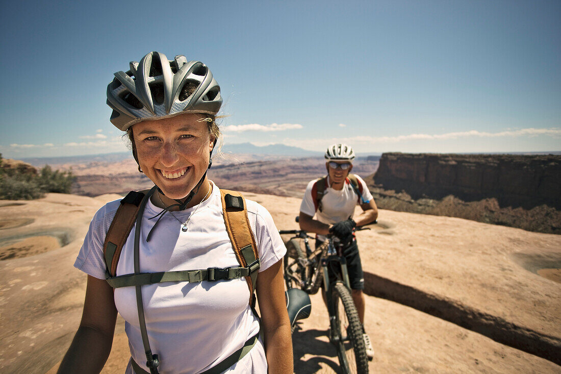 Portrait of a female mountain biker in her helmet, smiling at the camera in Utah Moab, Utah, USA