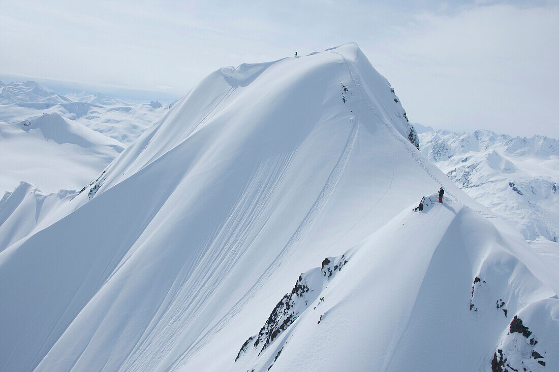 Two skiers on a snowy mountain getting ready to drop in Haines, Alaska Haines, Alaska, USA
