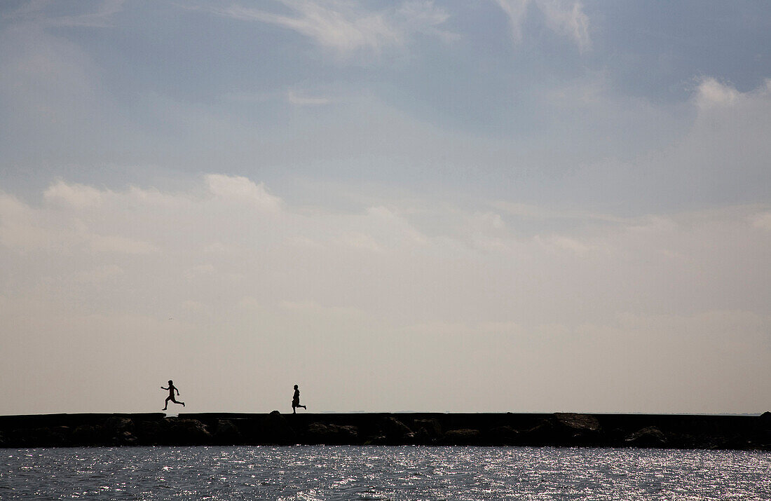 Two young people run on a pier … – License image – 70461555 lookphotos