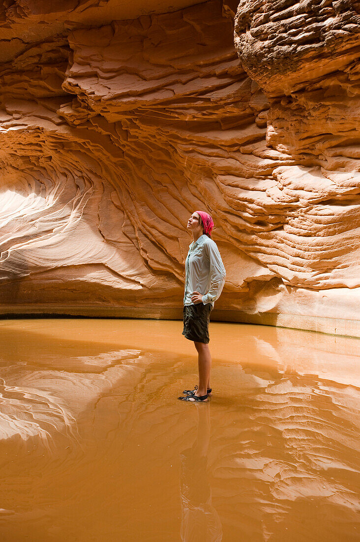 A young woman stands in a large pool of water and reflects the beauty of North Canyon at the Grand Canyon in Arizona Arizona, USA