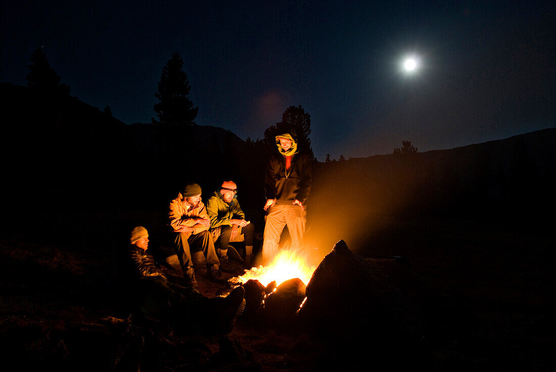 A group of campers sit around a camp fire for warmth in Yosemite, California Yosemite, California, USA