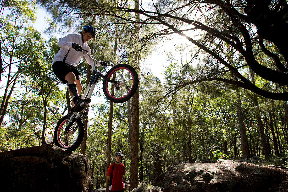 A Trials rider prepares to leap off a rock at Toohey Forest, Brisbane, Queensland, Australia Brisbane, Queensland, Australia