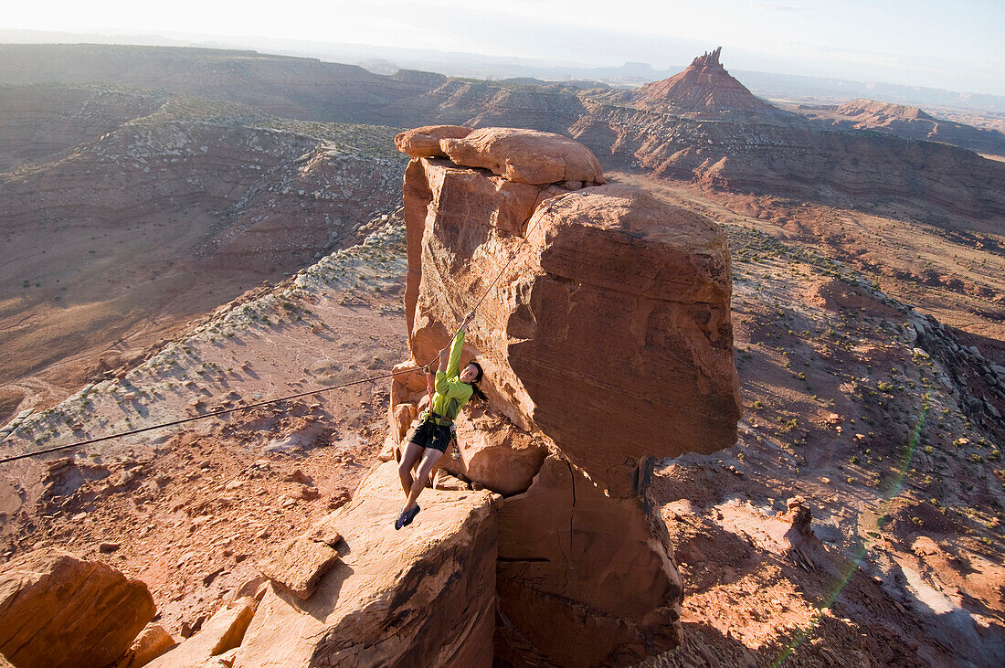 A woman completing a tyrolean traverse on the South Six Shooter Towers, Indian Creek, Monticello, Utah Monticello, Utah, USA