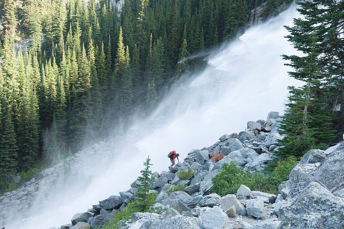 A man hiking next to waterfall, Enchantment Peaks, Alpine Lakes Wilderness, Leavenworth, Washington Leavenworth, Washington, USA