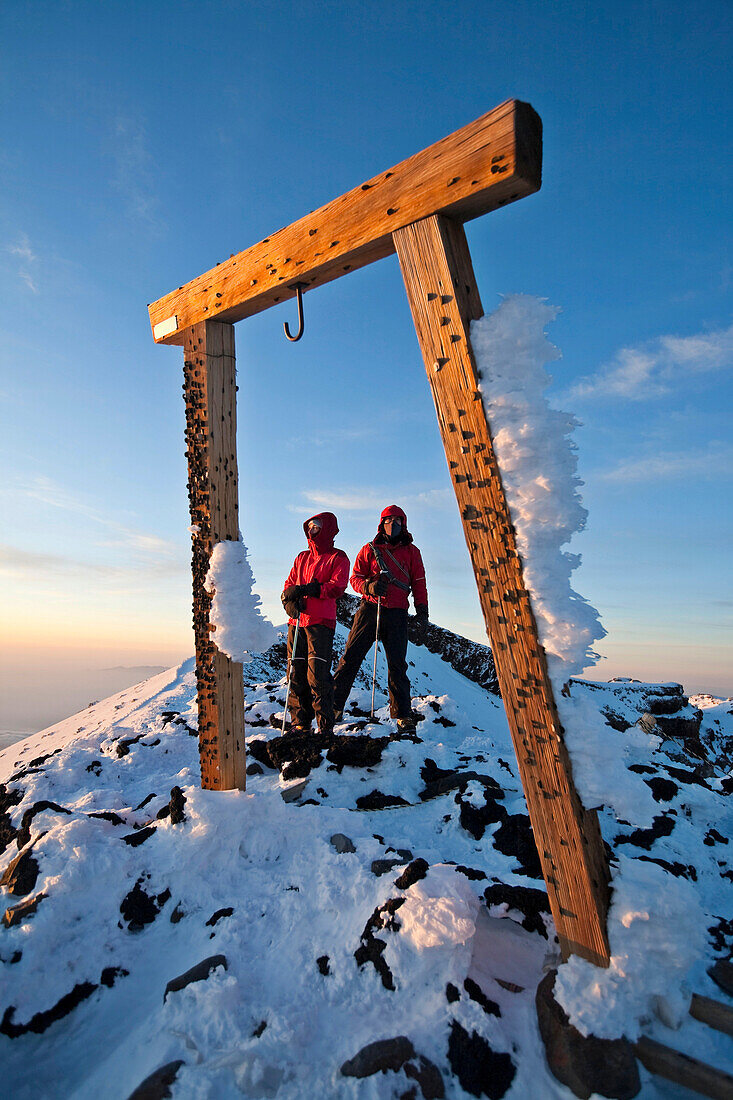 Two people are framed by a wooden gate on Mount Fuji, Honshu, Japan Honshu, Japan