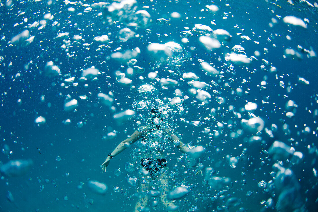 Underwater view of a swimmer behind a wall of bubbles in the tropical waters off of Mana Island, Fiji Mana Island, Fiji