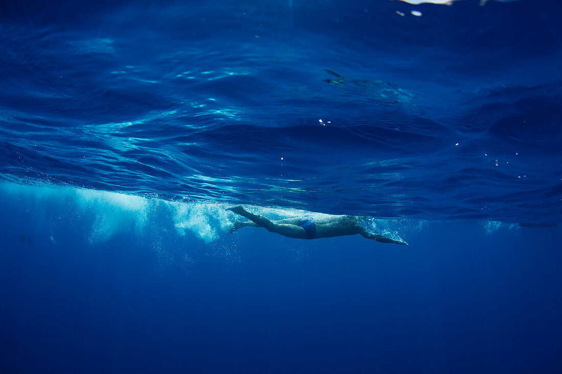 Underwater view of a swimmer enjoying a relaxing swim in the tropical waters off of Mana Island, Fiji Mana Island, Fiji