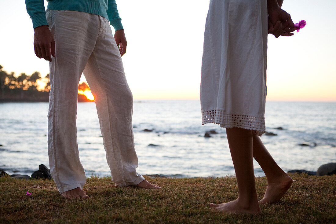 A man talks with a shy woman near the ocean at sunset Chacala, Nayarit, Mexico