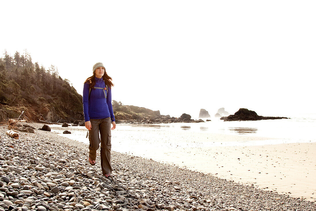 A woman hiking a secluded rocky beach Cannon Beach, Oregon, USA