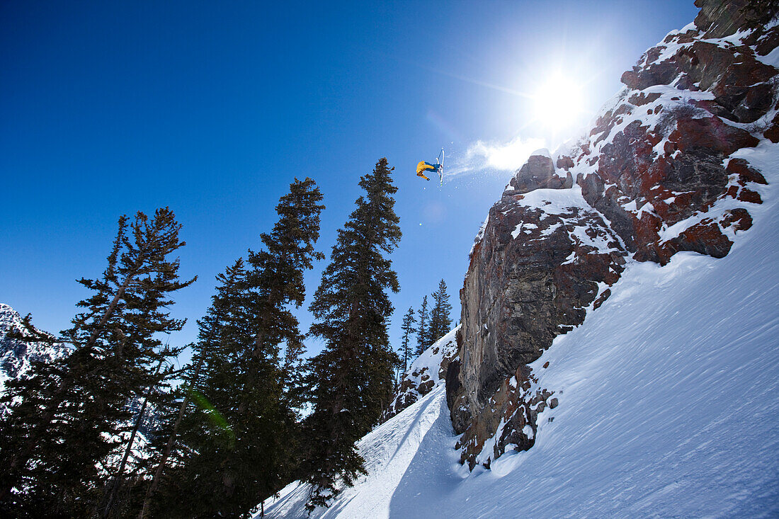 Male telemark skier front flips off a 60 foot cliff in Utah Salt Lake City, Utah, USA