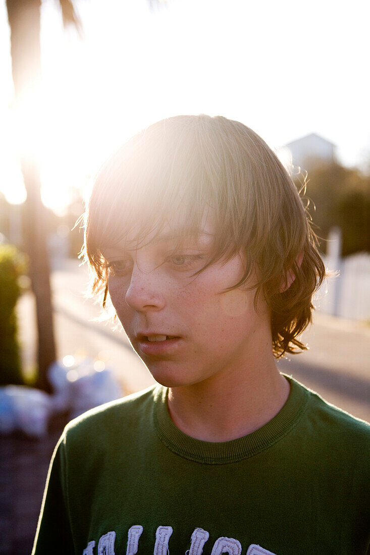 A teen boy is staring with the sun shining behind him Destin, Florida, USA