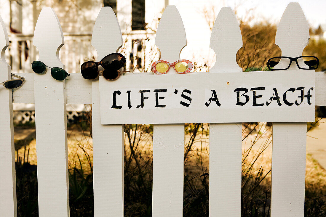 'A picket fence is covered with sunglasses and has a sign that reads ''life's a beach'' Destin, Florida, USA'