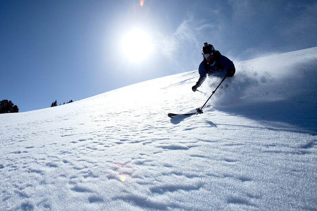 Low angle perspective of one man telemark skiing on a blue sky day Wendover, Nevada, USA