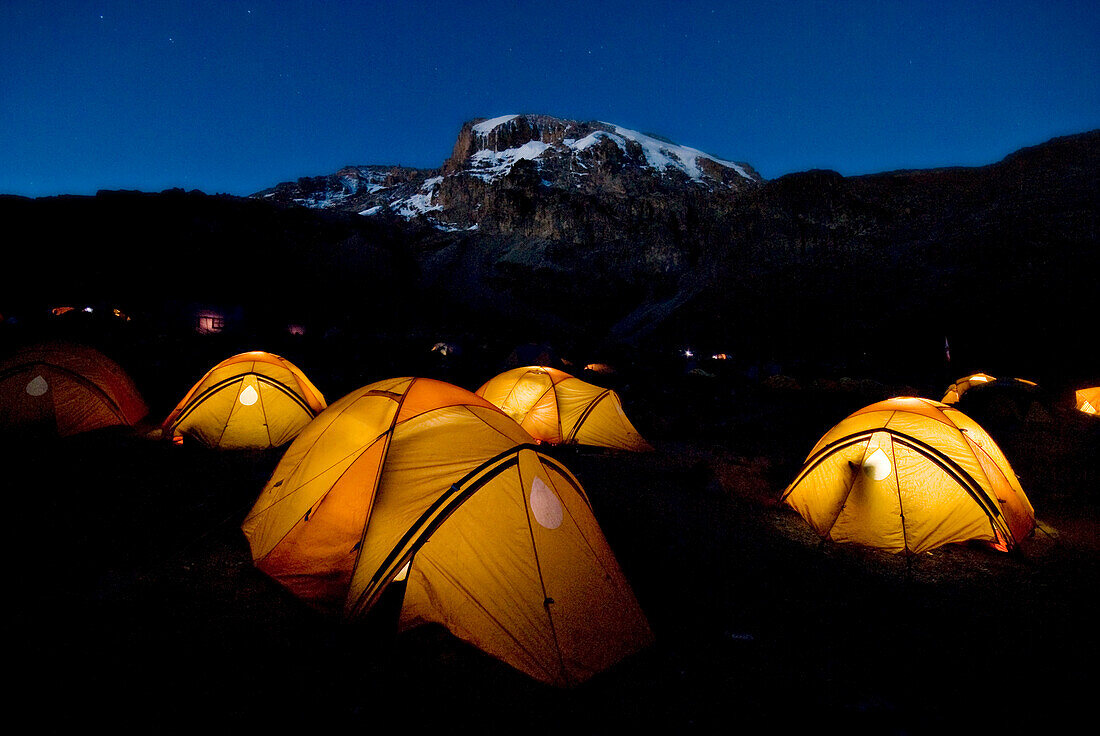 Tents illuminate the night 2, 000 ft. below the summit of Mt. Kilimanjaro Tanzania