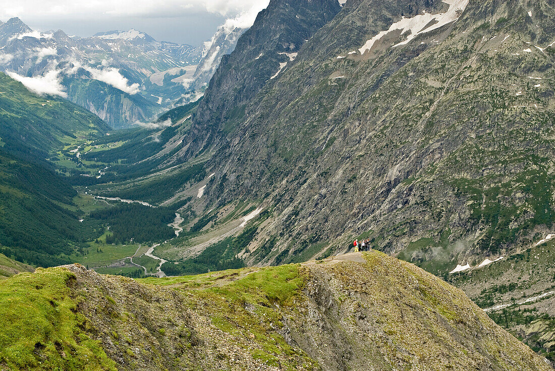 A group of hikers assemble on a lookout point, high above a deep valley Mont Blanc, France