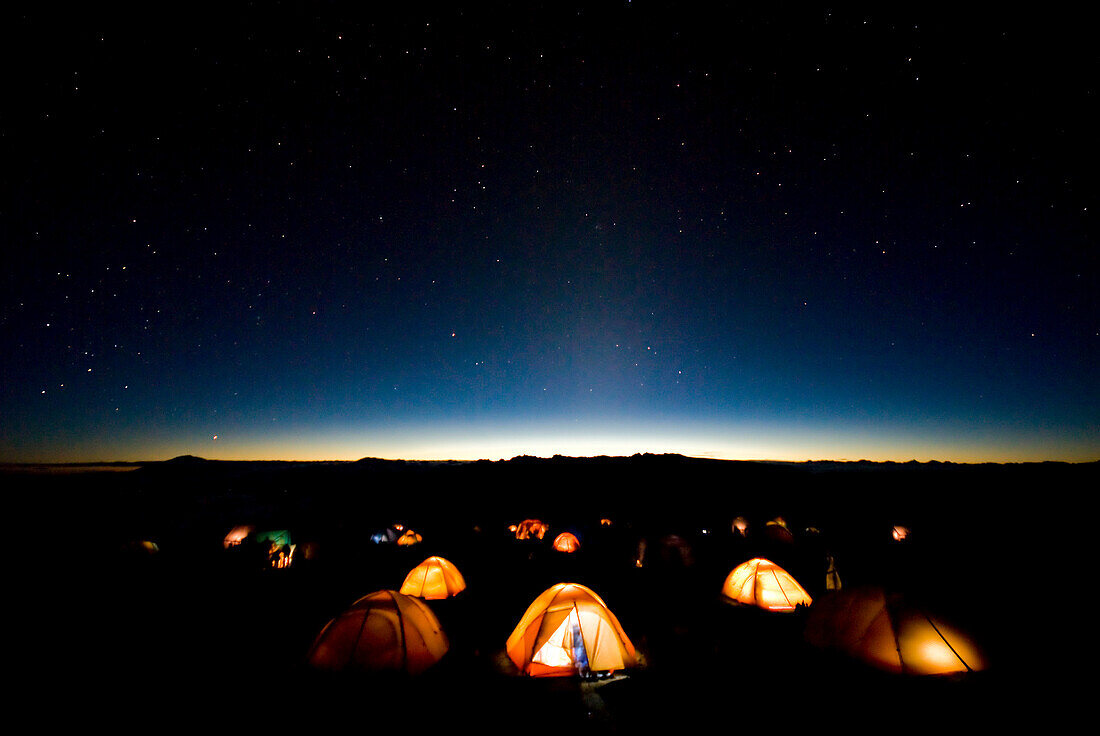 Tents illuminate the night as stars fill the sky on mMt. Kilimanjaro Tanzania