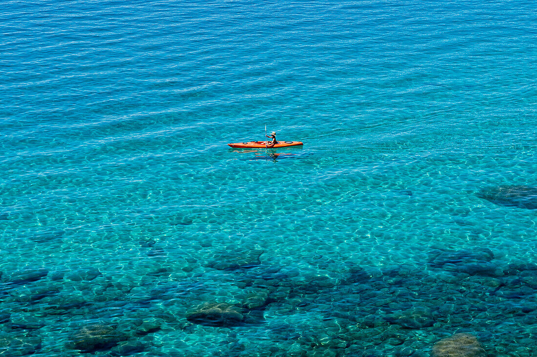 A single kayaker is out for a morning paddle on the pristine shores of Lake Tahoe, Nevada Incline Village, Nevada, USA