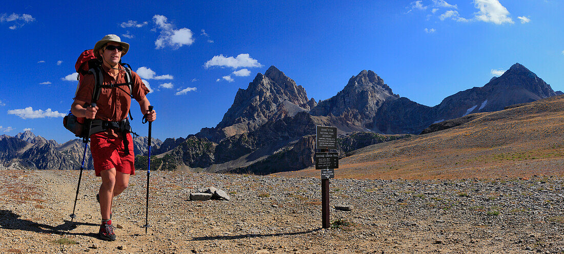 Solo hiker in Grand Teton National Park passing trail sign, Wyoming, USA