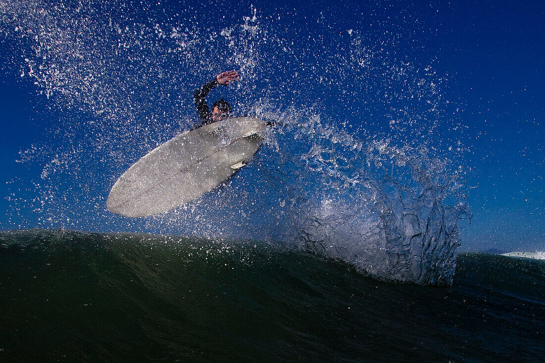 A male surfer does an air while surfing in Malibu, California Malibu, California, United States of America