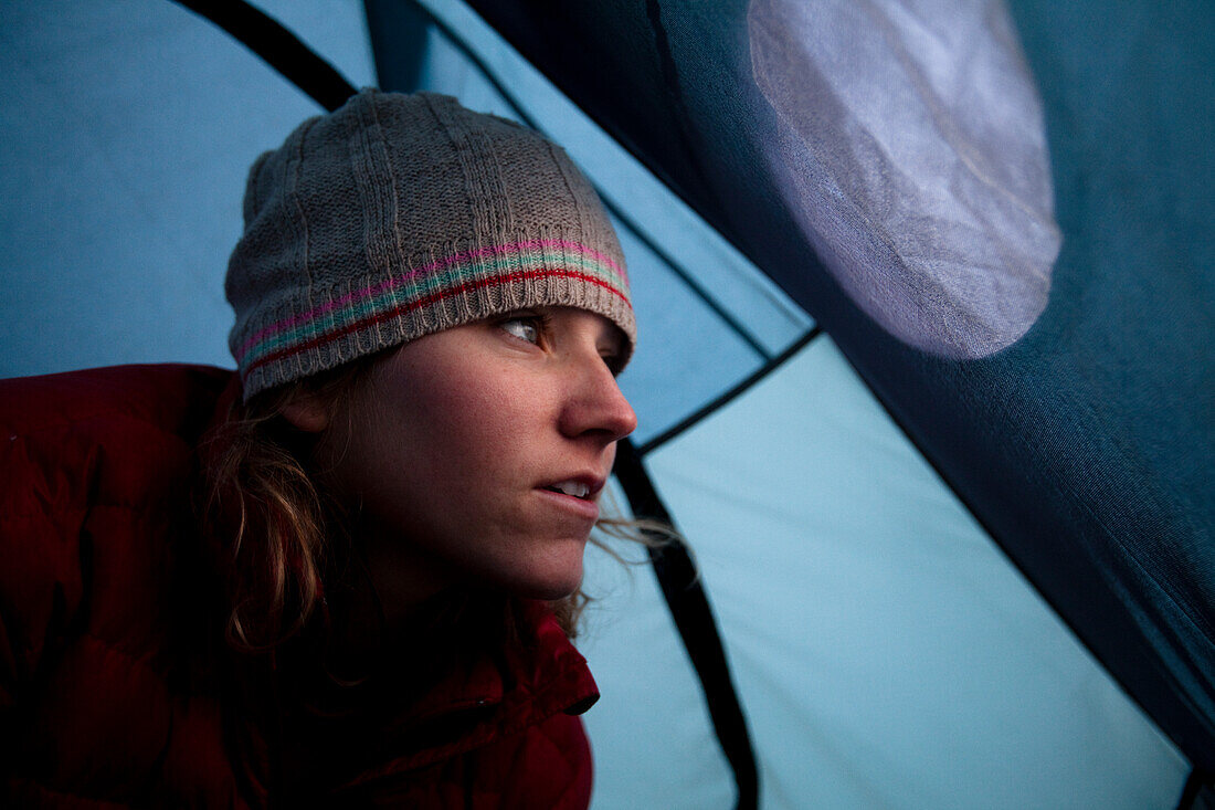 A woman looks out of her tent window while camping off the Kangamangus Highway near Conway, New Hampshire Conway, New Hampshire, United States of America