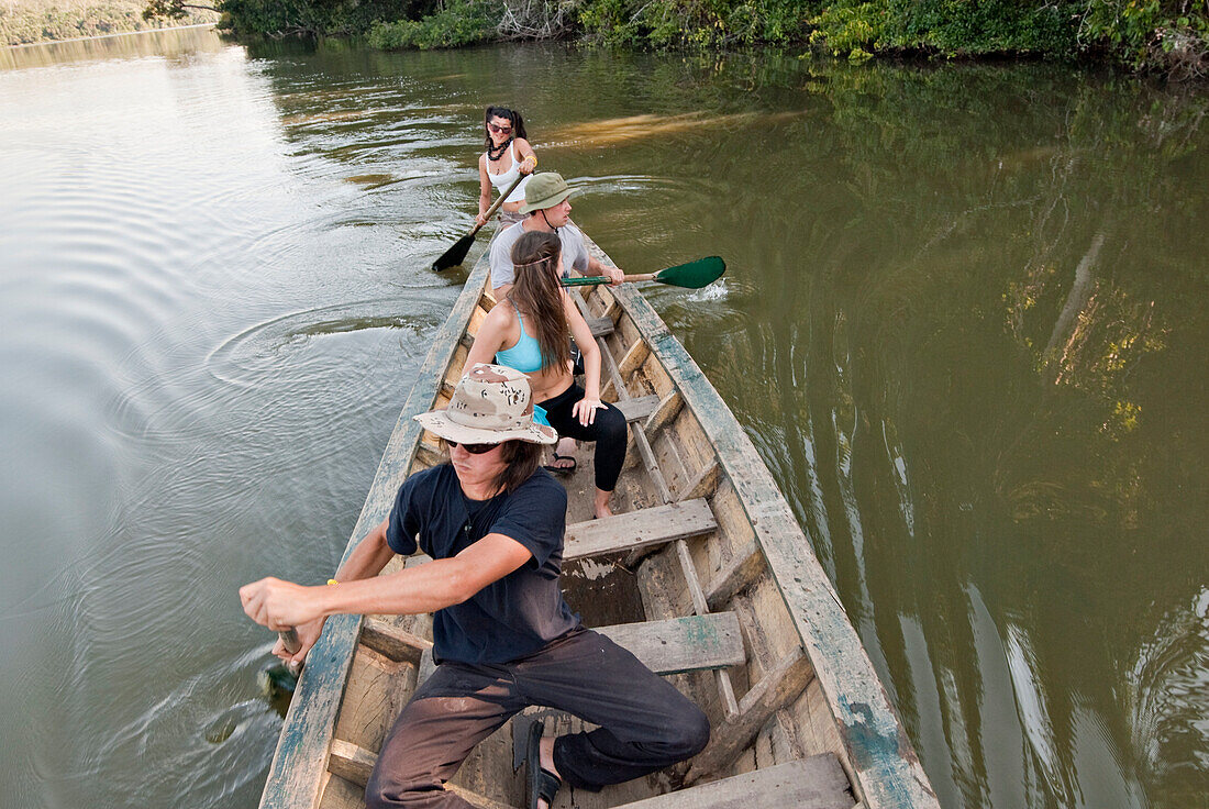 A group of young people paddling a canoe and having fun on lake sandoval Sandoval Lake, Amazon Rainforest, Puerto Maldanado, Peru, Peru