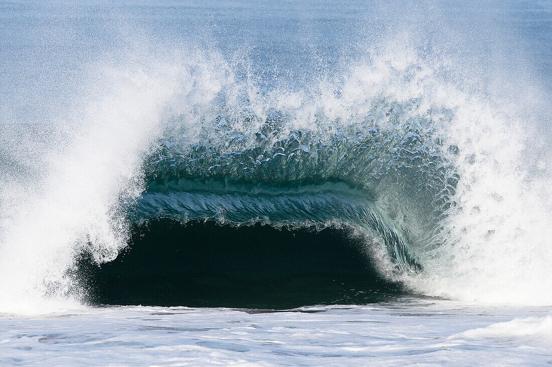 A large wave breaks with force over a shallow sandbar Malibu, California, United States of America