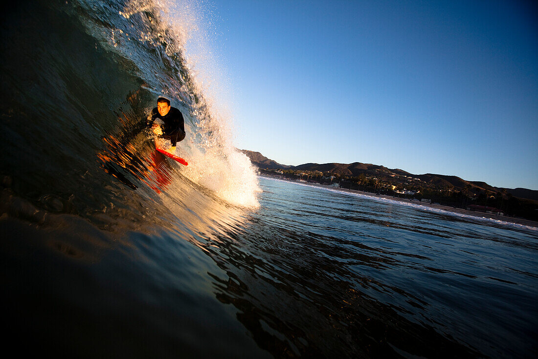 A male surfer gets barreled at Zuma beach in Malibu, California Malibu, California, United States of America