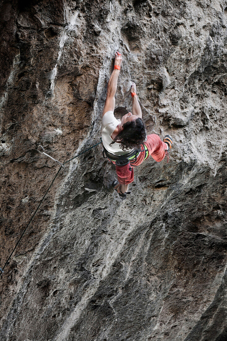 A middle aged woman wearing white tshirt and red pants rock climbing in Jilotepec, Estado de Mexico, Mexico Not applicable, Estado de Mexico, Mexico