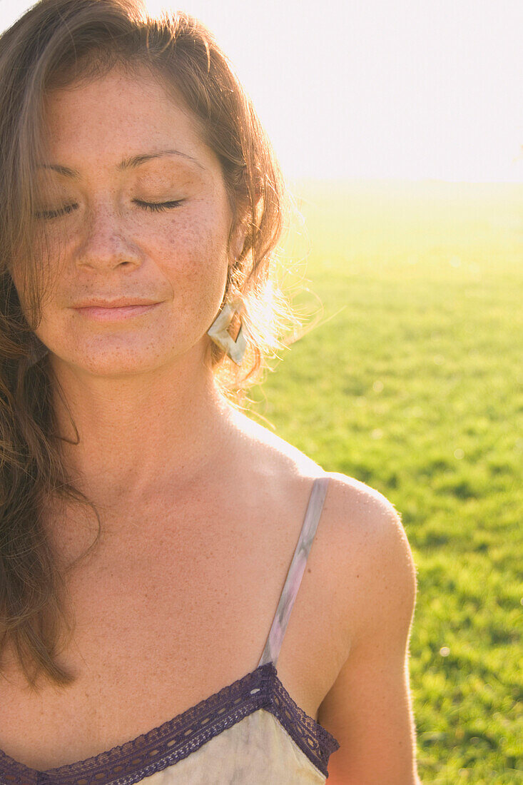 Portrait of woman in sunlit meadow, Kenneth Hahn State Park, CA