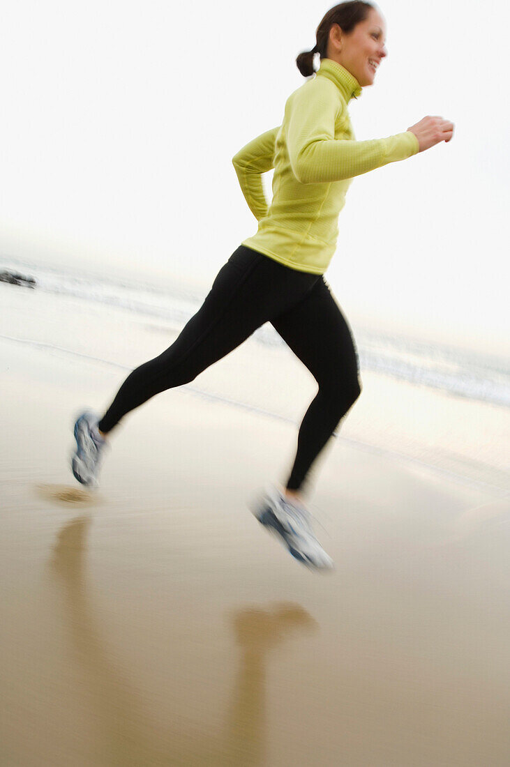 Hispanic woman running on beach, Newport Beach, CA