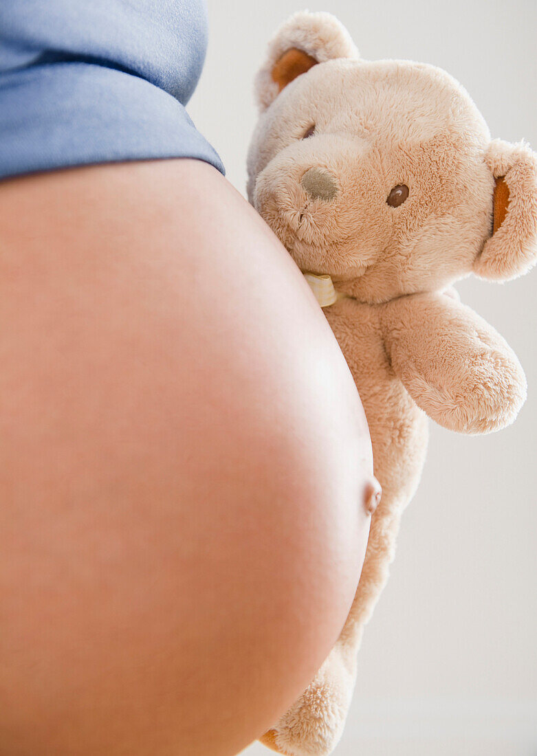 Pregnant Hispanic woman holding teddy bear, Jersey City, NJ