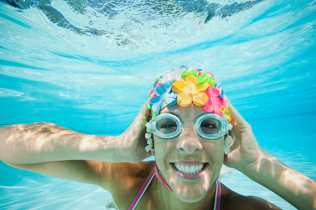 Hispanic woman in retro swimming cap underwater in swimming pool, Ladera Ranch, CA, USA